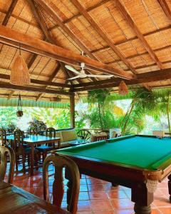 a pool table in a room with tables and chairs at Q Bungalows in Kep