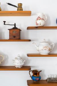 a row of wooden shelves with tea pots and cups at Villa Kalomira in Spetses
