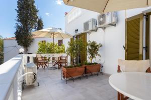 a balcony with a table and chairs and an umbrella at Villa Kalomira in Spetses