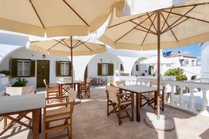 a patio with tables and chairs and umbrellas at Villa Kalomira in Spetses