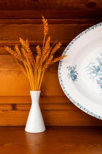 a white vase with a plant in it next to a plate at Villa Kalomira in Spetses