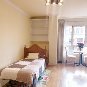 Schlafzimmer mit einem Bett, einem Tisch und einem Fenster in der Unterkunft Alcobendas Cómodo y luminoso Un dormitorio in Alcobendas