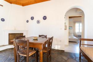 a dining room with a wooden table and chairs at Villa Kalomira in Spetses