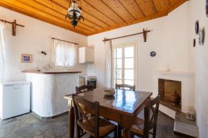 a kitchen and dining room with a wooden table and chairs at Villa Kalomira in Spetses
