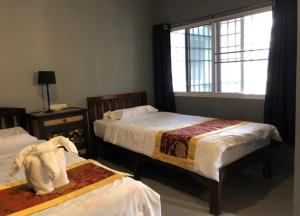 a hotel room with two beds and a window at Wooden hostel in Chiang Mai