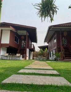 a house with a pathway in front of it at Wooden hostel in Chiang Mai