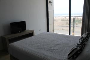 a bedroom with a bed and a flat screen tv at Apartamentos Tocororo in Cotillo