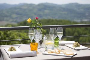 einen Tisch mit Weingläsern und Essen darauf in der Unterkunft Cascina Marcantonio in Acqui Terme