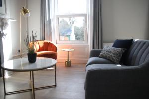 un soggiorno con divano e tavolo di Crawford House- ScholarLee Living Apartments a Cork