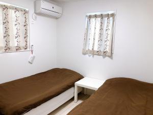 鎌倉市にあるAno House女性専用ゲストハウスのベッド2台と窓が備わる客室です。