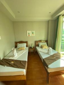 2 łóżka pojedyncze w pokoju z oknem w obiekcie Morning Star Hotel w mieście San Vicente