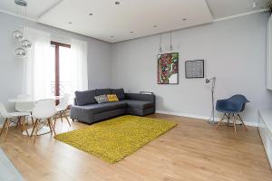 salon z kanapą i żółtym dywanem w obiekcie VIP Apartamenty Białystok w mieście Białystok