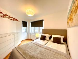 1 dormitorio con 1 cama grande y 2 ventanas en City Gästeapartment Leipzig Nord en Leipzig