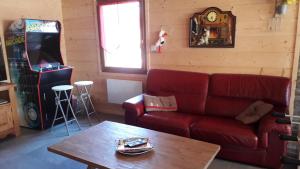 - un salon avec un canapé rouge et une table dans l'établissement Chalet de 3 chambres avec jacuzzi jardin amenage et wifi a Xonrupt Longemer a 5 km des pistes, à Xonrupt-Longemer