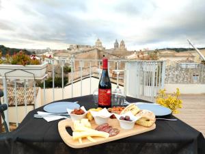 a table topped with a sandwich and a bottle of wine at Terrazza Dei Sogni in Ragusa