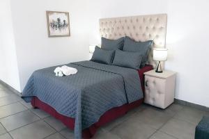 um quarto com uma cama com um edredom azul em Queens Palace em Pretoria