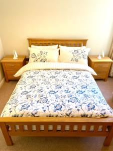 a bedroom with a bed with a blue and white comforter at Luxurious two-bedroom apartment in the centre of Peterborough in Peterborough