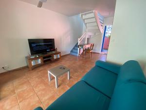 un salon avec un canapé bleu et une télévision dans l'établissement PALM SPRING, au Gosier