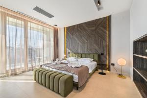a bedroom with a large bed with a large window at Seascape Villa in Eforie Sud