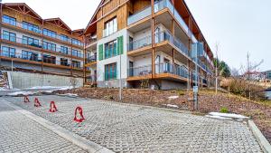 a street with red cones in front of a building at Apartament Bujać w Obłokach Karpatia - 5D Apartamenty in Karpacz
