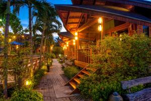 a building with a pathway next to a resort at Tique Series Boutique Resort (SHA Extra Plus) in Ban Hat Lek