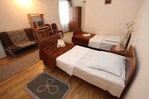 a room with two beds and a living room with at Guesthouse Goliati in Kutaisi