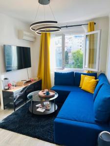 ein Wohnzimmer mit einem blauen Sofa und einem Tisch in der Unterkunft Superbe T3 - 11 minutes Palais, Croisette & Plages in Cannes