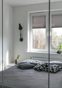 1 dormitorio con 1 cama grande y 2 ventanas en Tree&Lake Apartament Warszawa en Ząbki