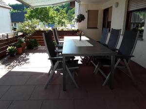 Une table et des chaises en bois sont disponibles sur la terrasse. dans l'établissement Ferienwohnung Monika Scholtz, à Königheim