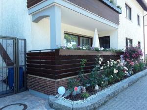 a brick wall with a flower garden in front of a house at Ferienwohnung Monika Scholtz in Königheim