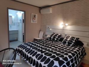a bedroom with a large black and white bed at La Peyrova in Saint-Sulpice-les-Feuilles