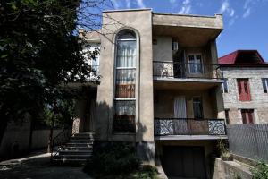 an apartment building with stairs and a balcony at Guesthouse Goliati in Kutaisi