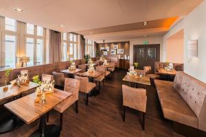 een restaurant met houten tafels en stoelen bij Hotel Alekto in Freiberg