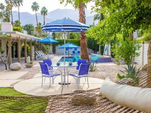 a patio with a table and chairs and umbrellas at Andiamo al Sole in Palm Springs