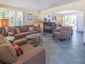 een woonkamer met een bank en stoelen en een open haard bij Reeves Garden House in Palm Springs