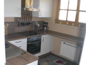 uma cozinha com armários brancos e um forno com placa de fogão em Fewo Böhmerwaldblick em Waldmünchen