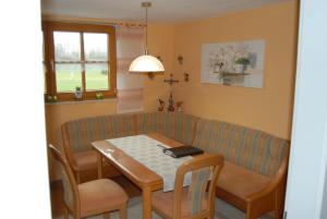 a dining room with a table and a couch at Fewo Böhmerwaldblick in Waldmünchen