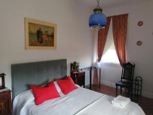 a bedroom with a bed with two red pillows at Vila Laura in Ribeira Grande