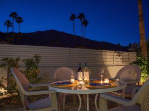 een tafel met stoelen en wijnflessen op een patio bij Boo Boo's Hideaway in Palm Springs
