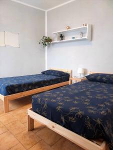two beds in a room with blue sheets at Casa Edda in Malcesine