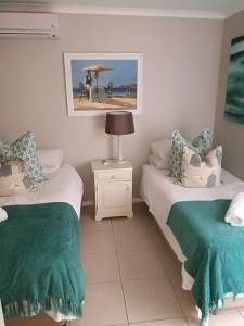 a bedroom with two beds and a lamp on a table at 8A Oyster Crescent in Durban