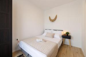 ein Schlafzimmer mit einem weißen Bett und einem Tisch in der Unterkunft Apartman Elena in Biograd na Moru