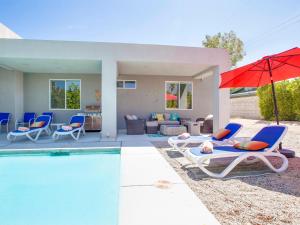 Casa con piscina con sillas y sombrilla en Sun Haven Escape, en Palm Springs