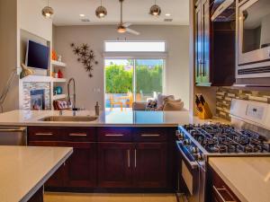 cocina con armarios de madera y horno con fogones en Sun Haven Escape, en Palm Springs