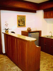 a kitchen with a wooden island in a room at Raya Grand Hotel in Nakhon Ratchasima