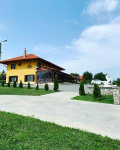 um edifício amarelo com uma entrada em frente em Pensiunea Cheile Apusenilor em Sănduleşti