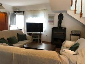 a living room with two couches and a flat screen tv at La Casa Grande in Benaocaz +37 photos