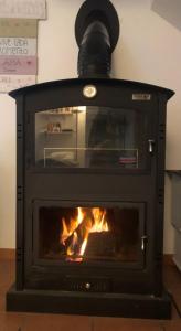 a stove with a fire in a room at La Casa Grande in Benaocaz
