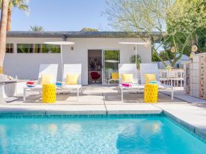 einen Pool mit Stühlen und ein Haus in der Unterkunft The Arrow in Palm Springs