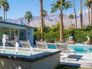 uma casa com uma piscina com cadeiras e uma fonte em Shag Lover em Palm Springs